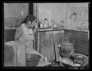 west indian woman in her kitchen with food cooking on the stove