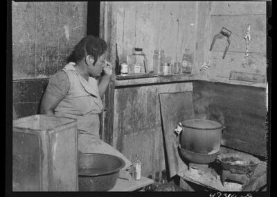 west indian woman in her kitchen with food cooking on the stove